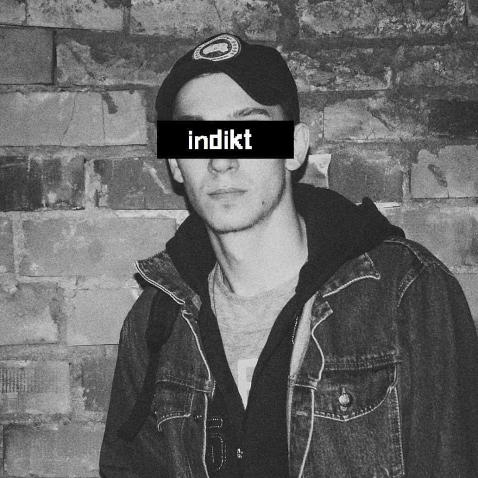 Indikt, portrait against a brick wall